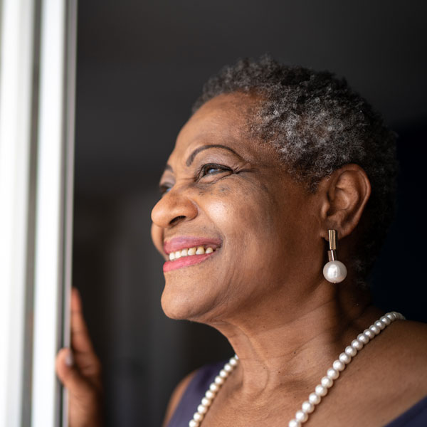 elderly woman smiling looking out window