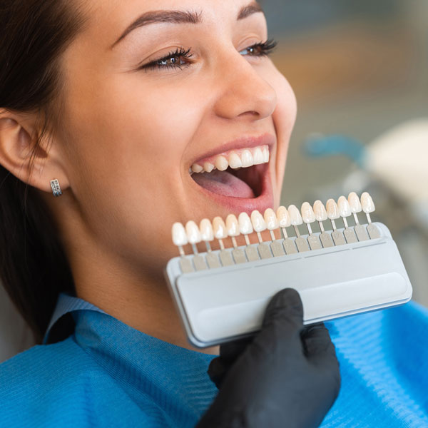 holding teeth whitening chart up to patient