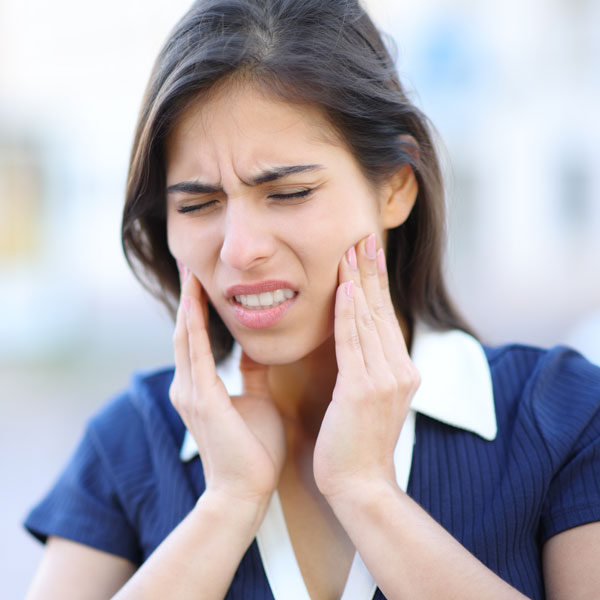 woman touching face in pain