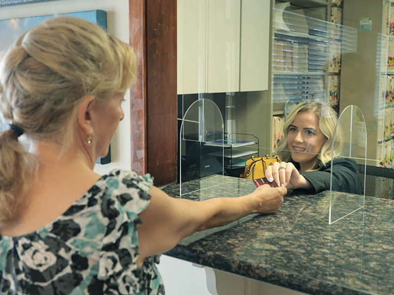 patient handing card to receptionist